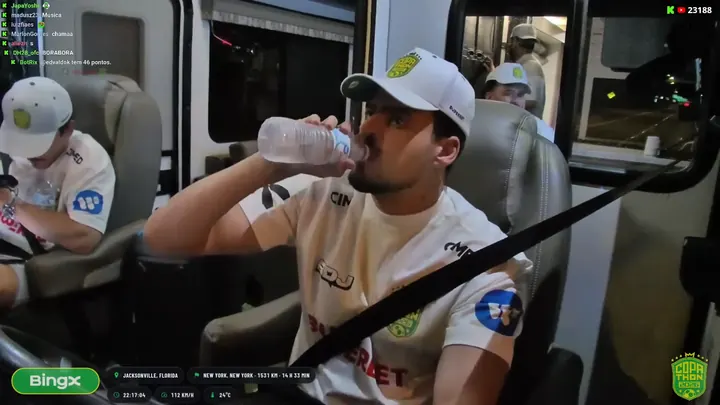 Jon no banco do motorhome durante a live, com o selo da BingX na tela