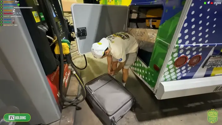 Parada num posto: a traseira do motorhome envelopado e a mala da equipe, com o selo da JV Holding na tela